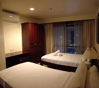 a hotel room with two beds and a window at Town suites Times Square in Kuala Lumpur