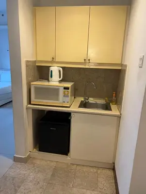 a small kitchen with a sink and a microwave at Town suites Times Square in Kuala Lumpur