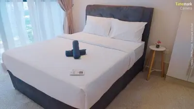 a bedroom with a large white bed with a blue headboard at trion in Kuala Lumpur