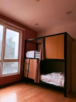 two bunk beds in a room with a window at Poshpack Skyline Hostel in Kuala Lumpur