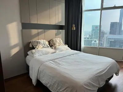 a bedroom with a white bed with a large window at Tomato Homestay By Sky Suites Klcc in Kuala Lumpur