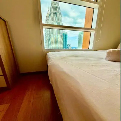 a bedroom with a window with a view of a skyscraper at Sky suites klcc by sky view in Kuala Lumpur