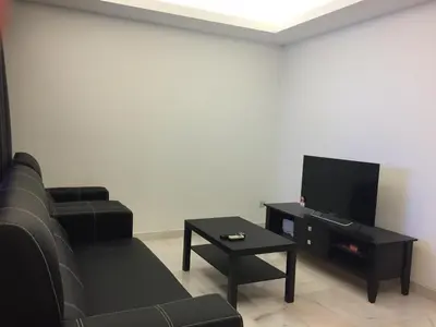 a living room with a couch and a tv at The Forum Kuala Lumpur in Kuala Lumpur