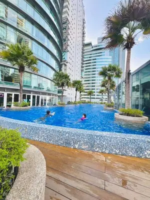 people swimming in a large swimming pool in a city at Vortex suites Near Klcc By I&J in Kuala Lumpur