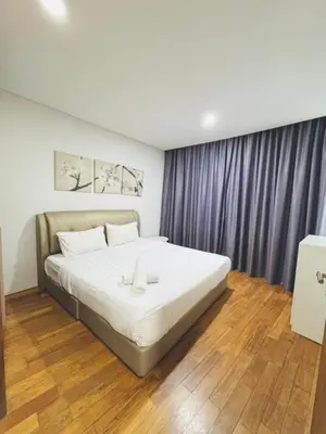a bedroom with a large white bed with purple curtains at Vortex suites Near Klcc By I&J in Kuala Lumpur