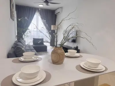 a table with plates and cups and a vase with flowers at 3 Bedrooms KLCC View PlazaRah,Kg Baru next to Rembayung in Kuala Lumpur