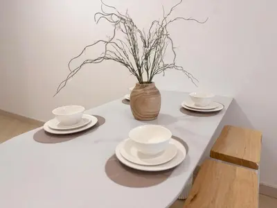 a table with plates and cups and a vase with flowers at 3 Bedrooms KLCC View PlazaRah,Kg Baru next to Rembayung in Kuala Lumpur