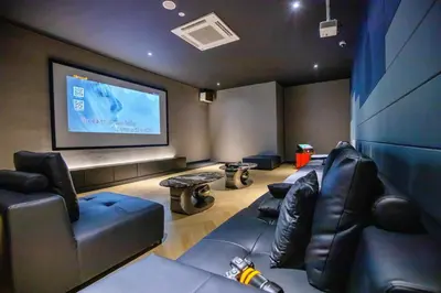 a cinema room with leather couches and a projection screen at Skyline Kuala Lumpur near Lalaport by Cityscape in Kuala Lumpur