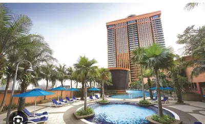 a resort with a pool and palm trees and a building at Time Square Mountain View Apartment KL in Kuala Lumpur