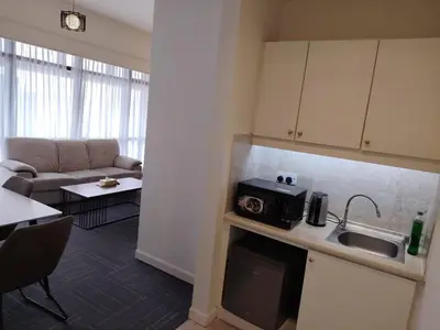 a kitchen with a sink and a microwave in a living room at Time Square Mountain View Apartment KL in Kuala Lumpur