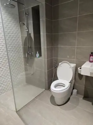 a bathroom with a shower and a toilet and a sink at Kuala Lumpur Suites Quill in Kuala Lumpur