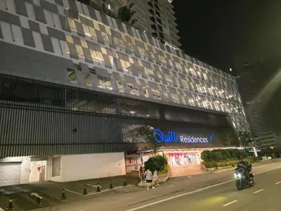 a person riding a motorcycle in front of a building at Kuala Lumpur Suites Quill in Kuala Lumpur