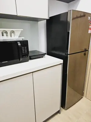 a kitchen with a black microwave and a refrigerator at Infinitum suites KLCC Sky Pool by EXA in Kuala Lumpur