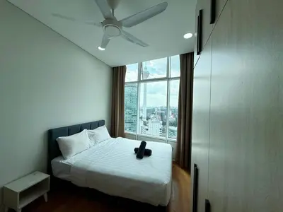 a bedroom with a bed with a ceiling fan and a window at Sky suites klcc by Aisyah in Kuala Lumpur