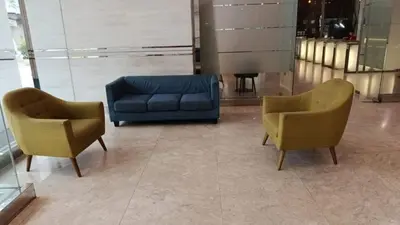 two chairs and a blue couch in a lobby at Binjai 8 KLCC BY Service Suites in Kuala Lumpur
