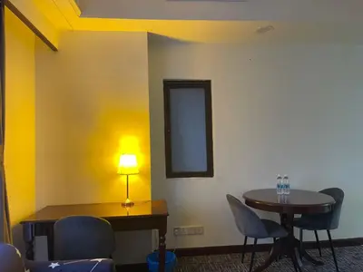 a room with a table and chairs and a lamp at Aurora Suites BUKIT At Times Square in Kuala Lumpur