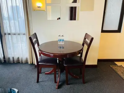 a wooden table and two chairs with water bottles on it at Aurora Suites BUKIT At Times Square in Kuala Lumpur