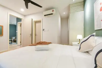 a bedroom with a large white bed with a ceiling fan at Fairlane Residence near Bukit Bintang KL in Kuala Lumpur