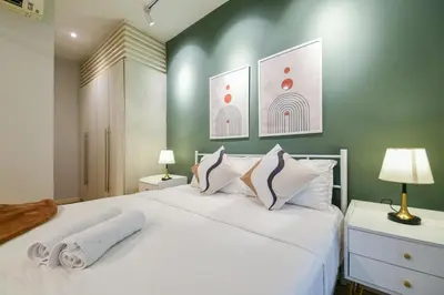 a bedroom with a large white bed with two lamps at Fairlane Residence near Bukit Bintang KL in Kuala Lumpur