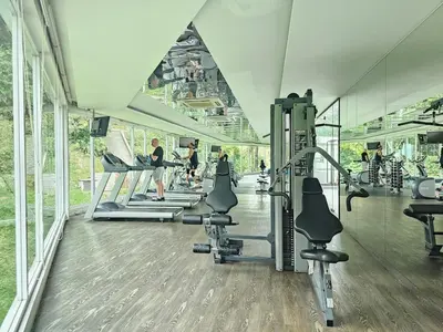 a gym with tread machines and people in the background at Cozy Suites 2 to 5pax near Sri Hartamas Mont Kiara in Kuala Lumpur