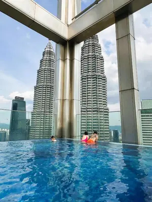 a infinity pool on the roof of a building with tall buildings at Tropicana Residences CoolStay in Kuala Lumpur