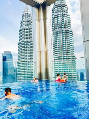 a group of people in a infinity pool on the roof of a skyscraper at Tropicana Residences CoolStay in Kuala Lumpur