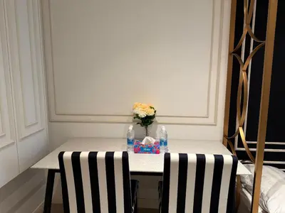 a table with a vase of flowers and two chairs at Axon Residence KL Luxury Bukit Bintang in Kuala Lumpur