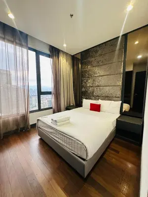 a bedroom with a large bed with white sheets and red pillows at City towen klcc by TTR in Kuala Lumpur