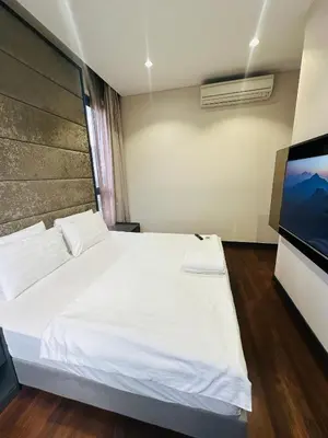 a bedroom with a white bed and a flat screen tv at City towen klcc by TTR in Kuala Lumpur