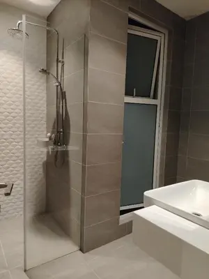 a shower with a glass door next to a sink at NEO Quill Residences klcc in Kuala Lumpur