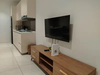 a living room with a flat screen tv on a wall at NEO Quill Residences klcc in Kuala Lumpur
