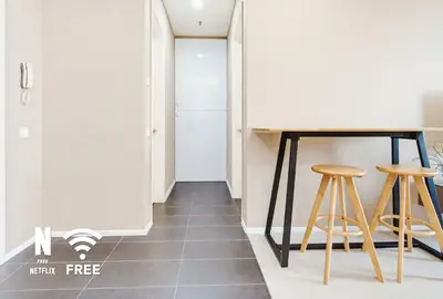 a hallway with a table and two stools at Arcoris SOHO Mont Kiara , Stylish 1 Bedroom Retreat in Kuala Lumpur