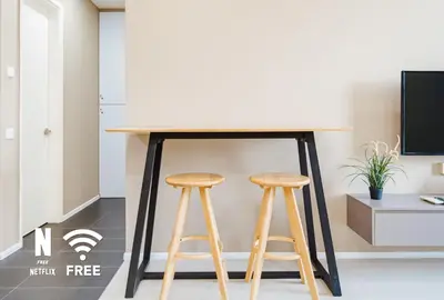 a table in a room with two stools at Arcoris SOHO Mont Kiara , Stylish 1 Bedroom Retreat in Kuala Lumpur
