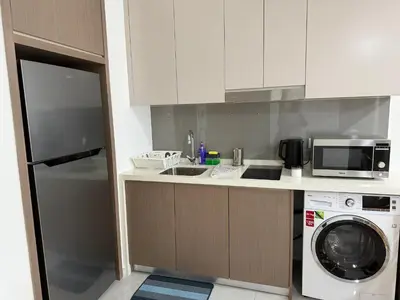 a kitchen with a washing machine and a microwave at Bukit Bintang Suites KLCC by YBS in Kuala Lumpur