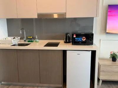 a kitchen with a counter with a sink and a refrigerator at Bukit Bintang Suites KLCC by YBS in Kuala Lumpur