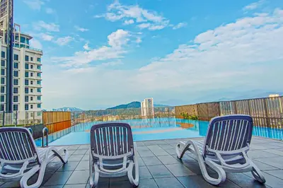 a balcony with three chairs and a swimming pool at Sky Pool at 3 Towers Ampang by HCK in Kuala Lumpur