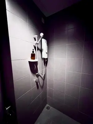 a bathroom with a shower with a hair dryer on the wall at Mercu Summer Suites KLCC by Jk Privy Homes - Entire Studio in Kuala Lumpur