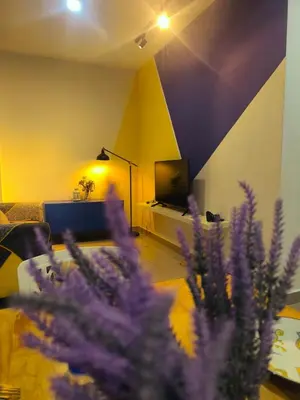 a living room with purple flowers and a tv at 10 Mins to KLCC Cozy Place to Stay in Kuala Lumpur