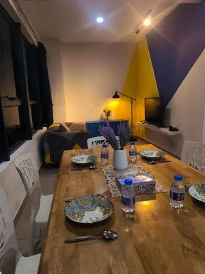 a living room with a wooden table with plates on it at 10 Mins to KLCC Cozy Place to Stay in Kuala Lumpur