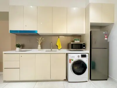 a kitchen with a washing machine and a microwave at Veone Hotel Kuala Lumpur in Kuala Lumpur