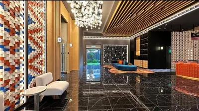 a lobby with chairs and a chandelier in a building at Staycay Majestic Residence KL in Kuala Lumpur
