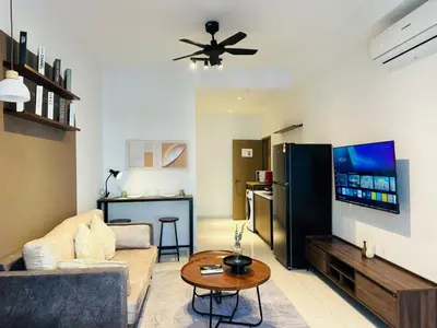 a living room with a couch and a tv and a table at LA Majestic Suites at KlCC in Kuala Lumpur