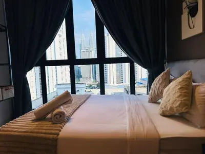 a bedroom with a large bed with a large window at LA Majestic Suites at KlCC in Kuala Lumpur