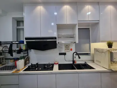 a kitchen with white cabinets and a sink and a stove at Awani3 Homestay Setapak, KL in Kuala Lumpur