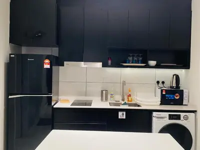 a kitchen with black cabinets and a black refrigerator at Axon Residence premium Apartment KL in Kuala Lumpur