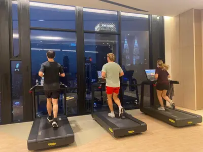 a group of people riding on exercise bikes in a gym at Axon Residence premium Apartment KL in Kuala Lumpur