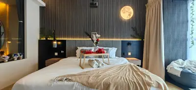 a bedroom with a large white bed with shoes on it at pertama residency jacuzzi projector 120