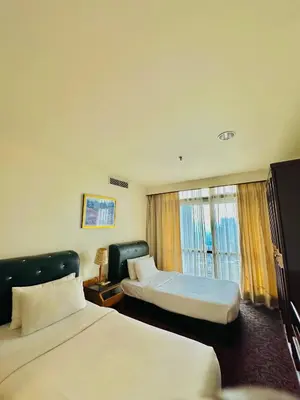 a hotel room with two beds and a window at Times Square Services suite at kl Bukit Bintang SAkL in Kuala Lumpur