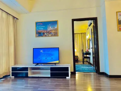 a living room with a flat screen tv on a tv stand at Times Square Services suite at kl Bukit Bintang SAkL in Kuala Lumpur