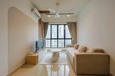 a living room with a couch and a tv at One Maxim Sentul By LuxeStay in Kuala Lumpur
